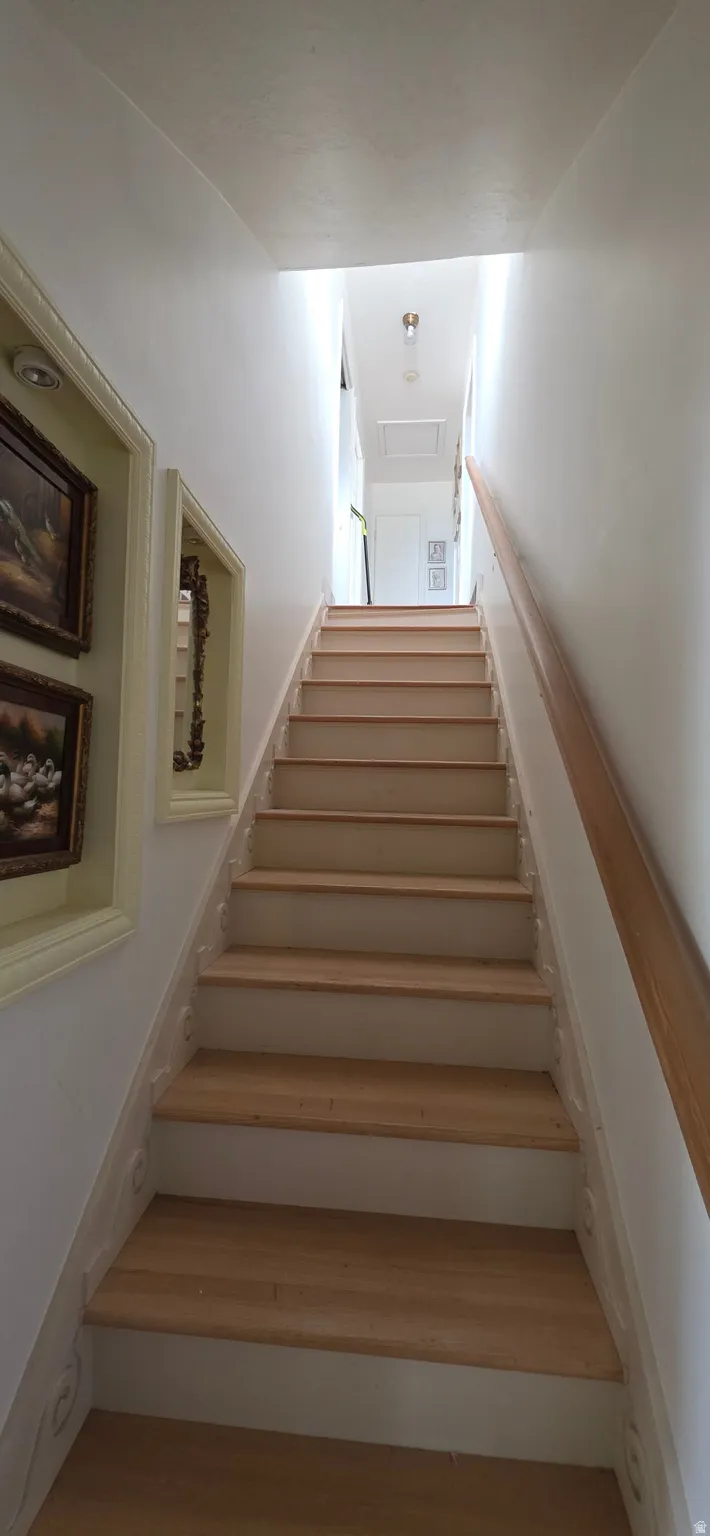 Light wood-finish staircase with white risers and a natural wood handrail