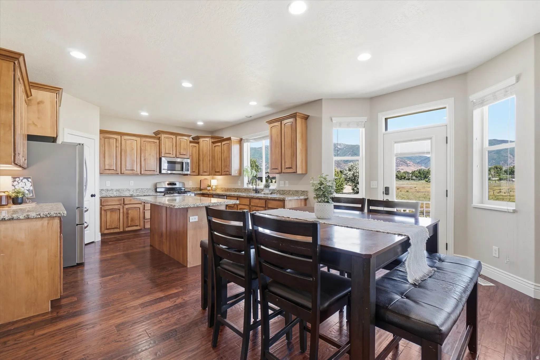 Open-concept kitchen and dining area with wood-finish flooring
