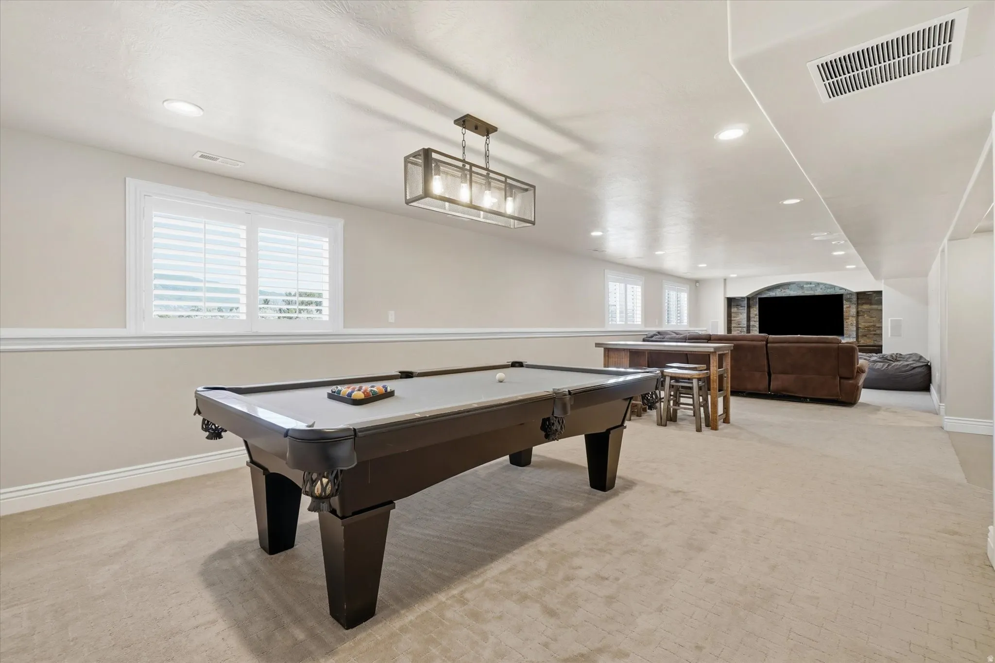 Basement recreation room with plantation shutters.