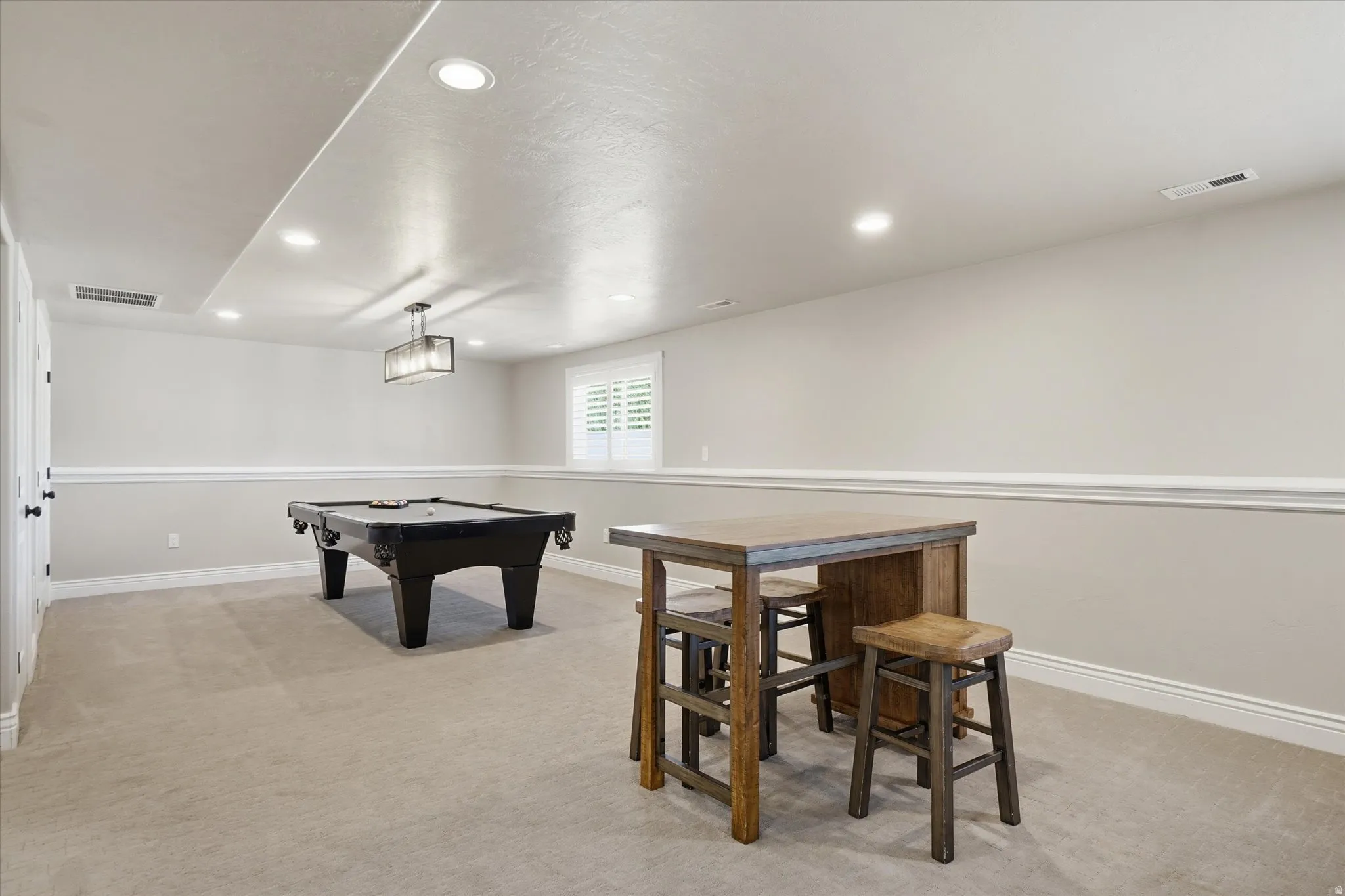 Basement recreation room with plantation shutters.