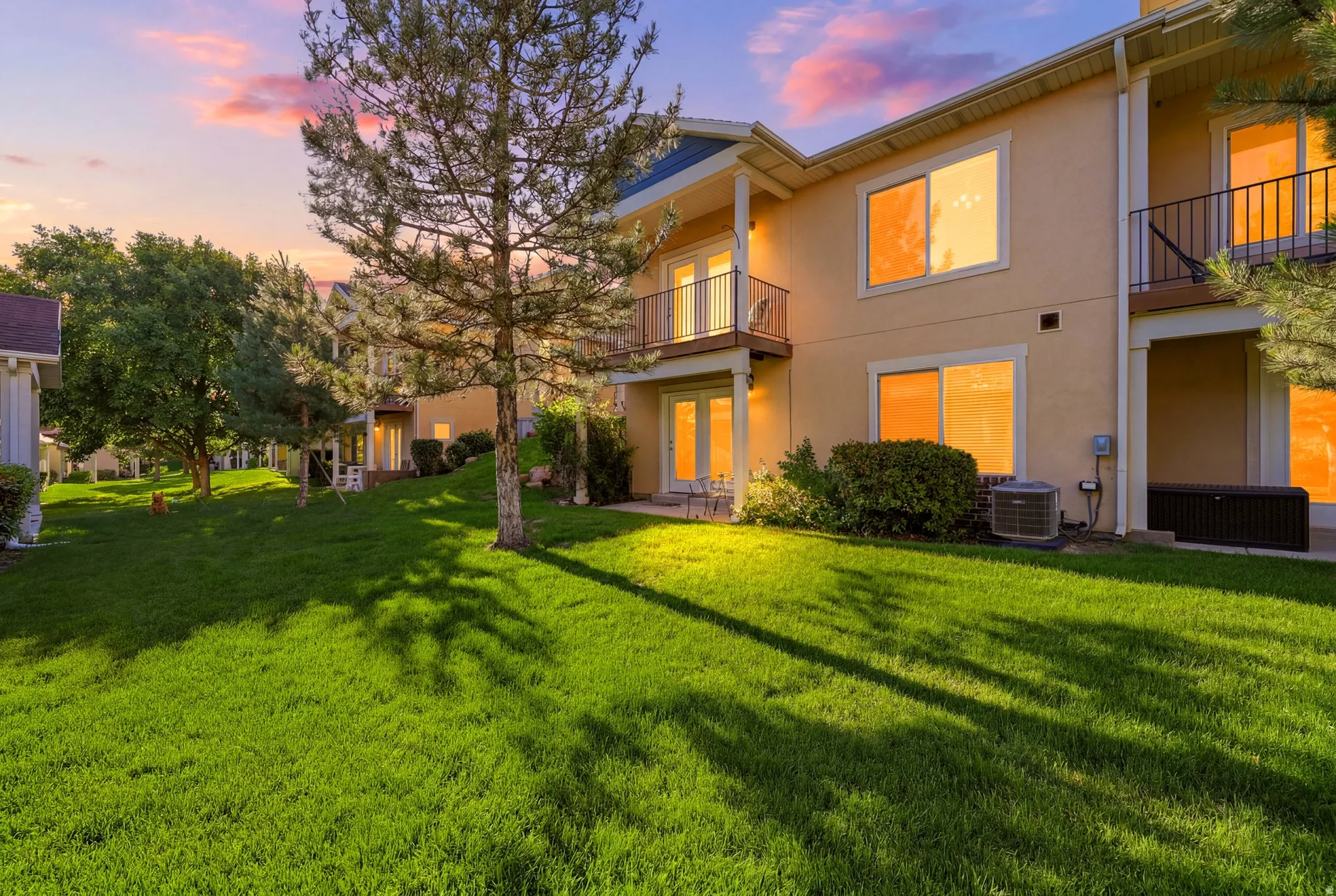 Rear exterior featuring stucco finish and multiple balconies with dark railings