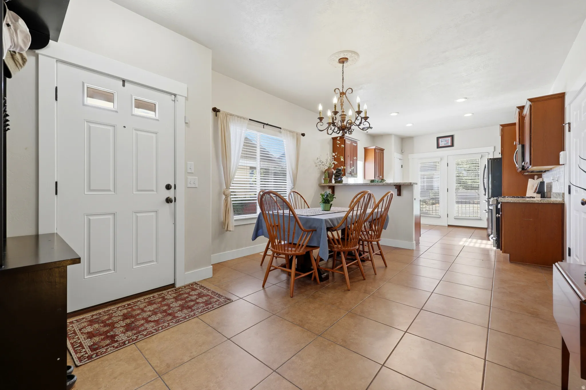 Open-concept living space featuring expansive tile flooring and a kitchen with wood-finish cabinetry