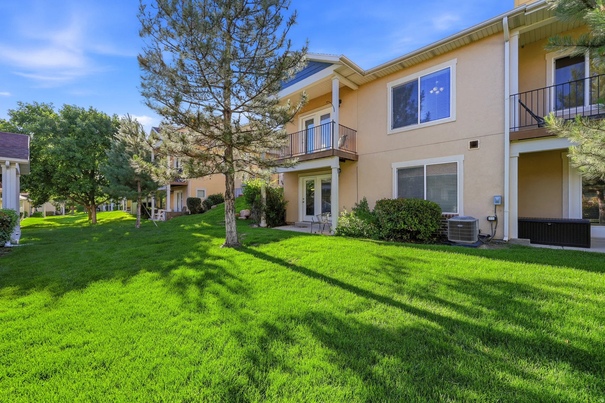 Expansive green lawn bordering a multi-story building with stucco siding