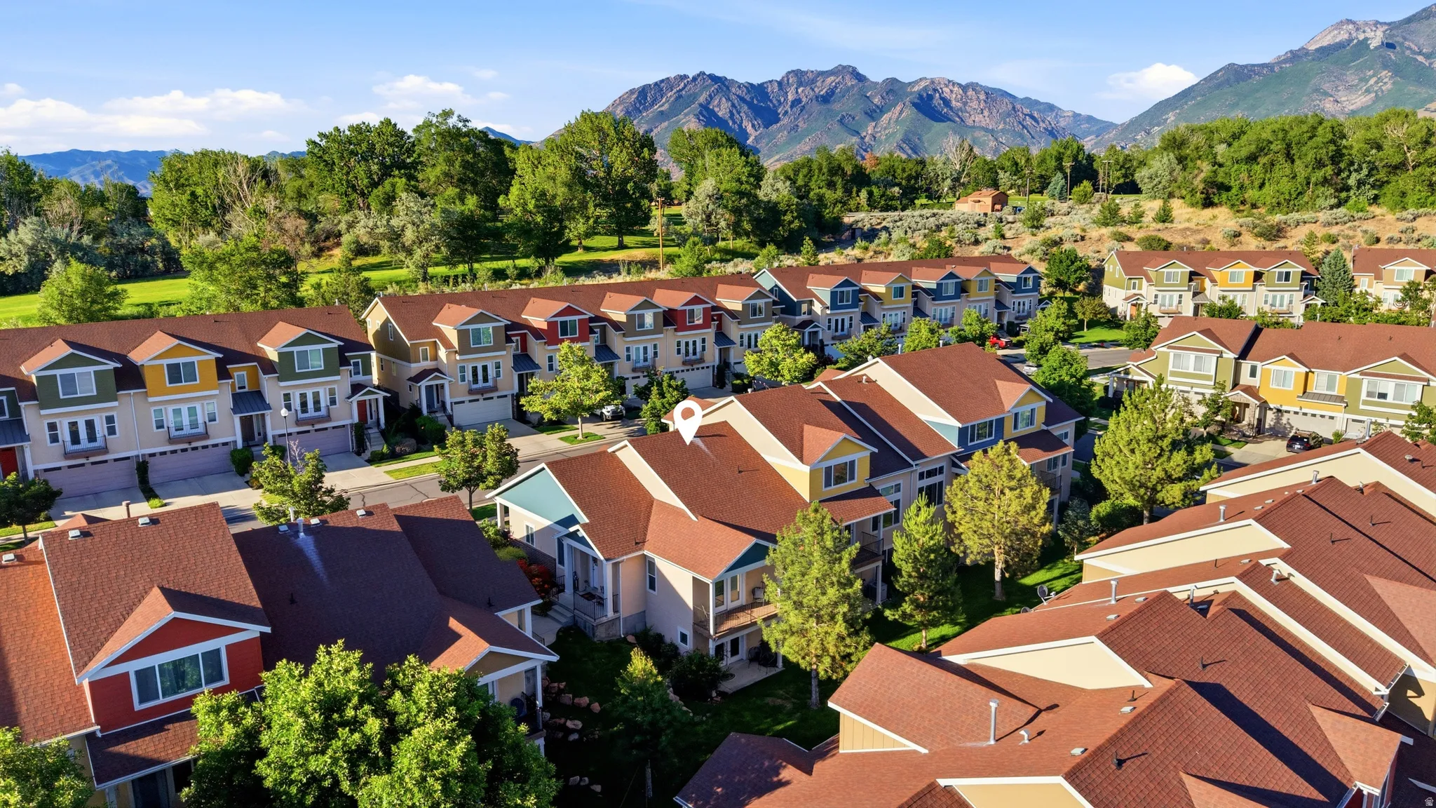Community of multi-level residences featuring varied exterior finishes, brown shingle roofing, and integrated garages