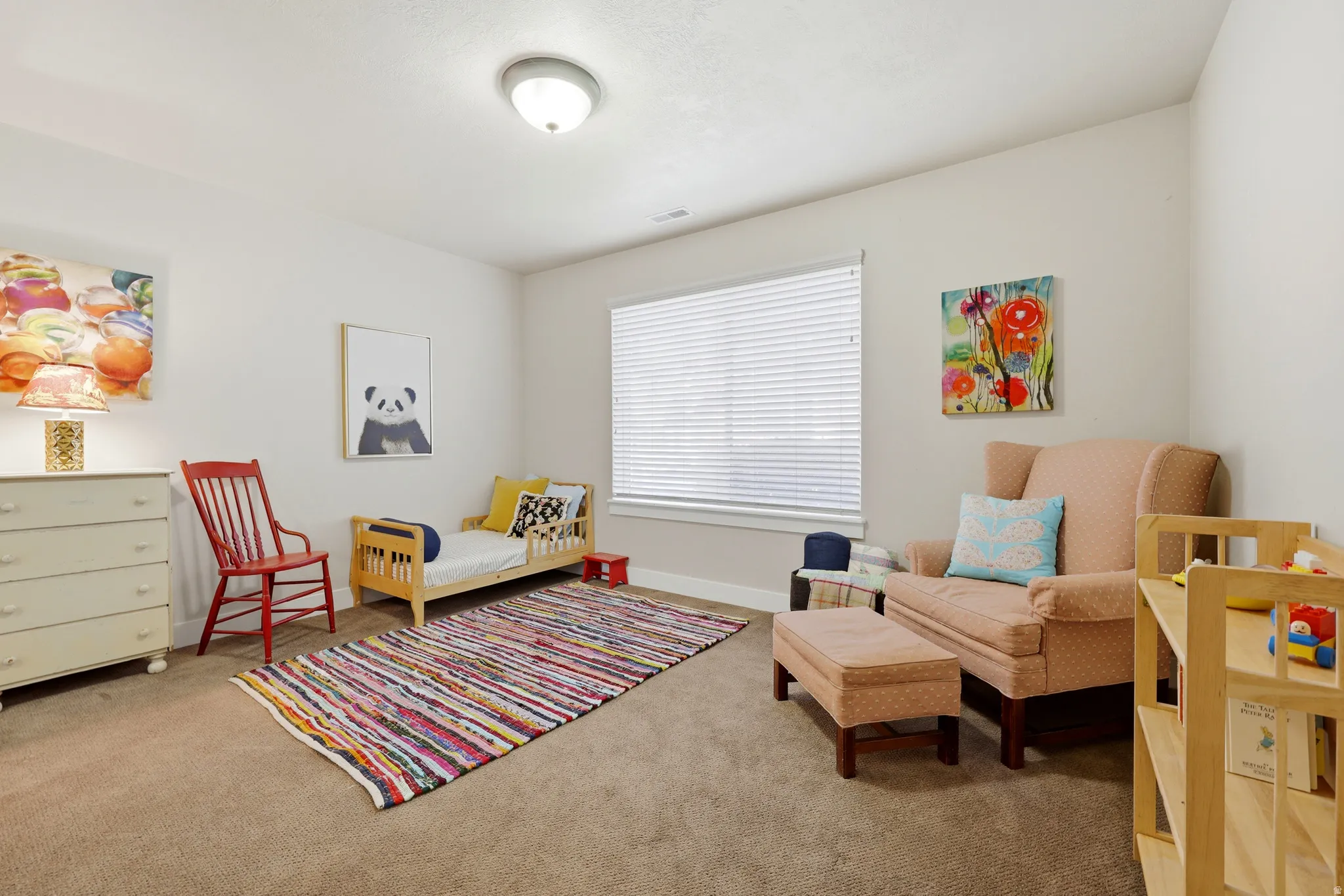 Carpeted room featuring a ceiling-mounted light fixture and a window with blinds