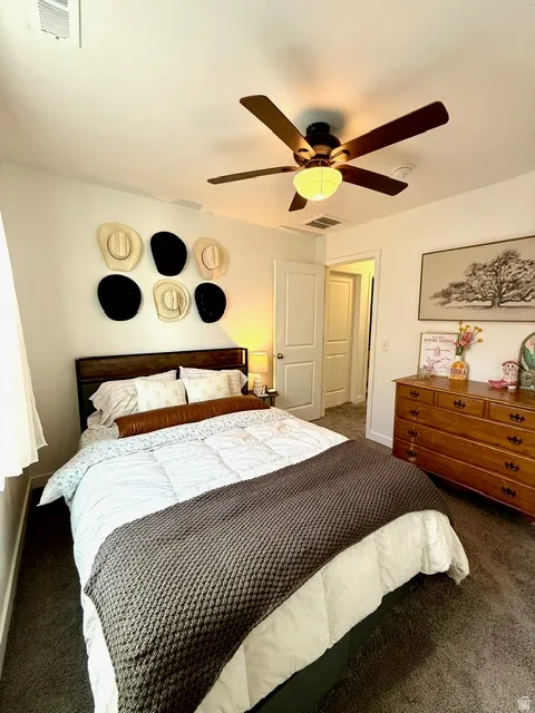 Bedroom featuring wall-to-wall carpeting and a dark wood headboard