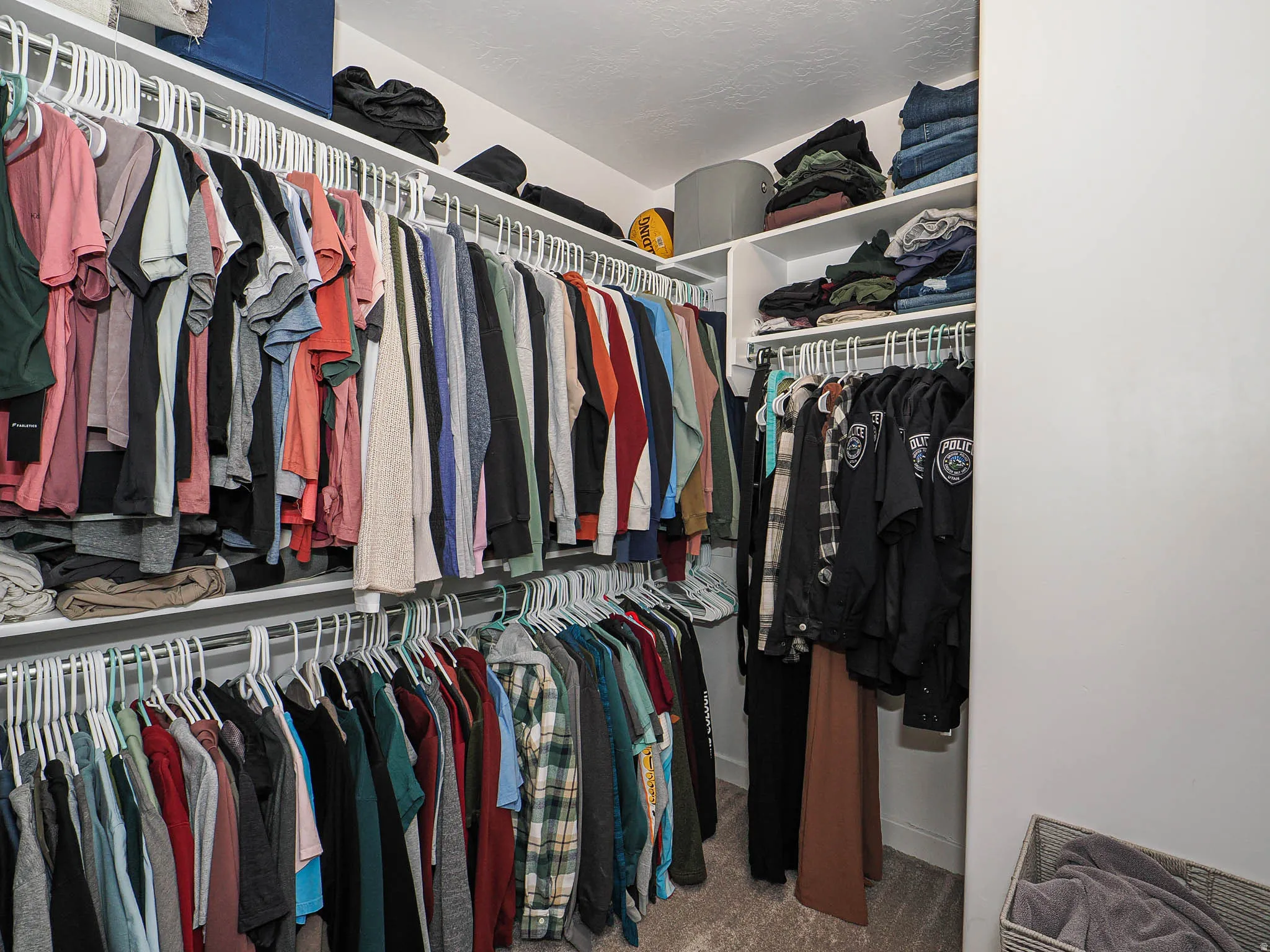 Walk-in closet with extensive built-in shelving, multiple hanging rods, and integrated storage compartments