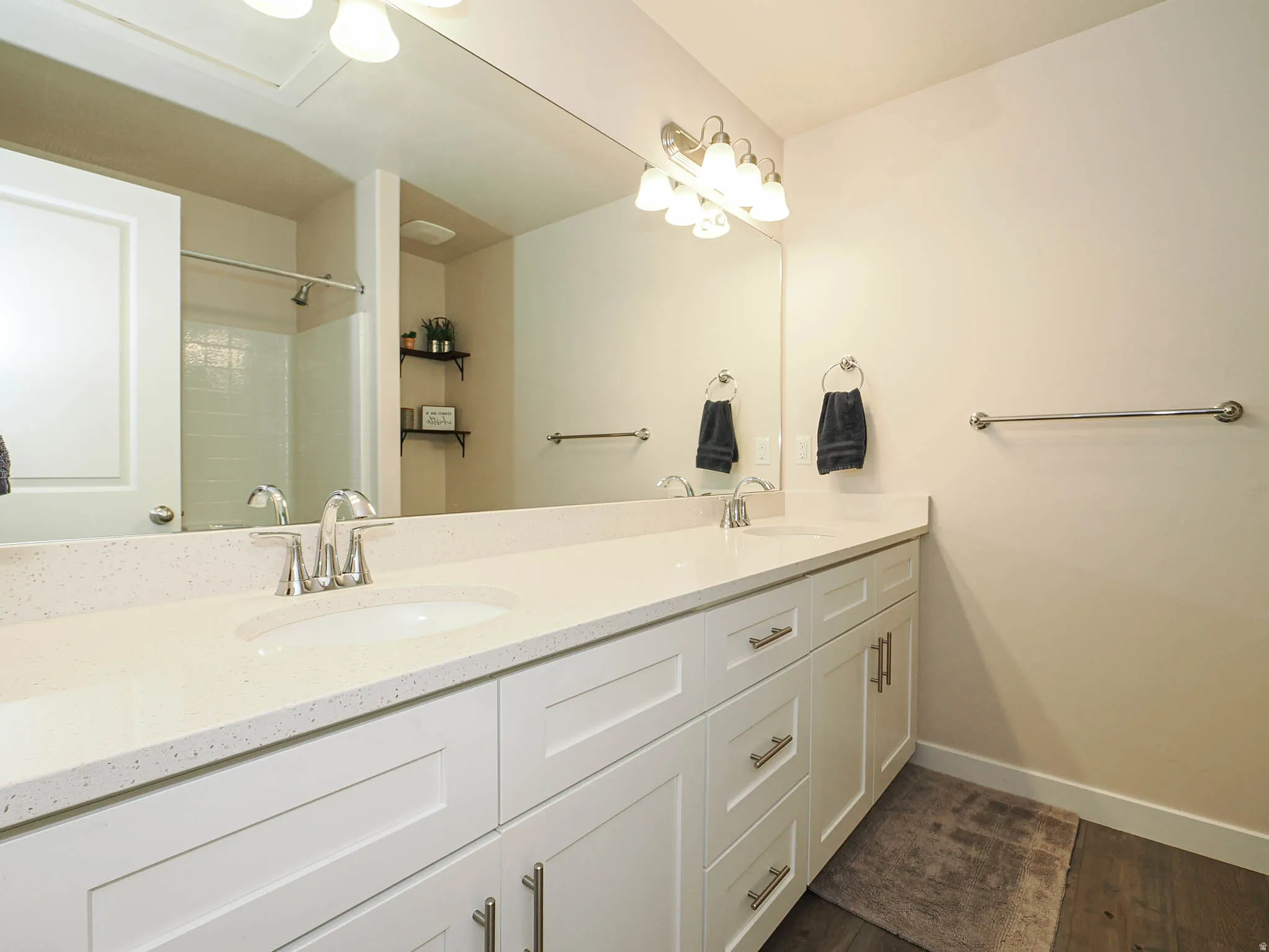 Main Bathroom. Dual vanity with white cabinetry and light-colored countertops, featuring brushed nickel hardware