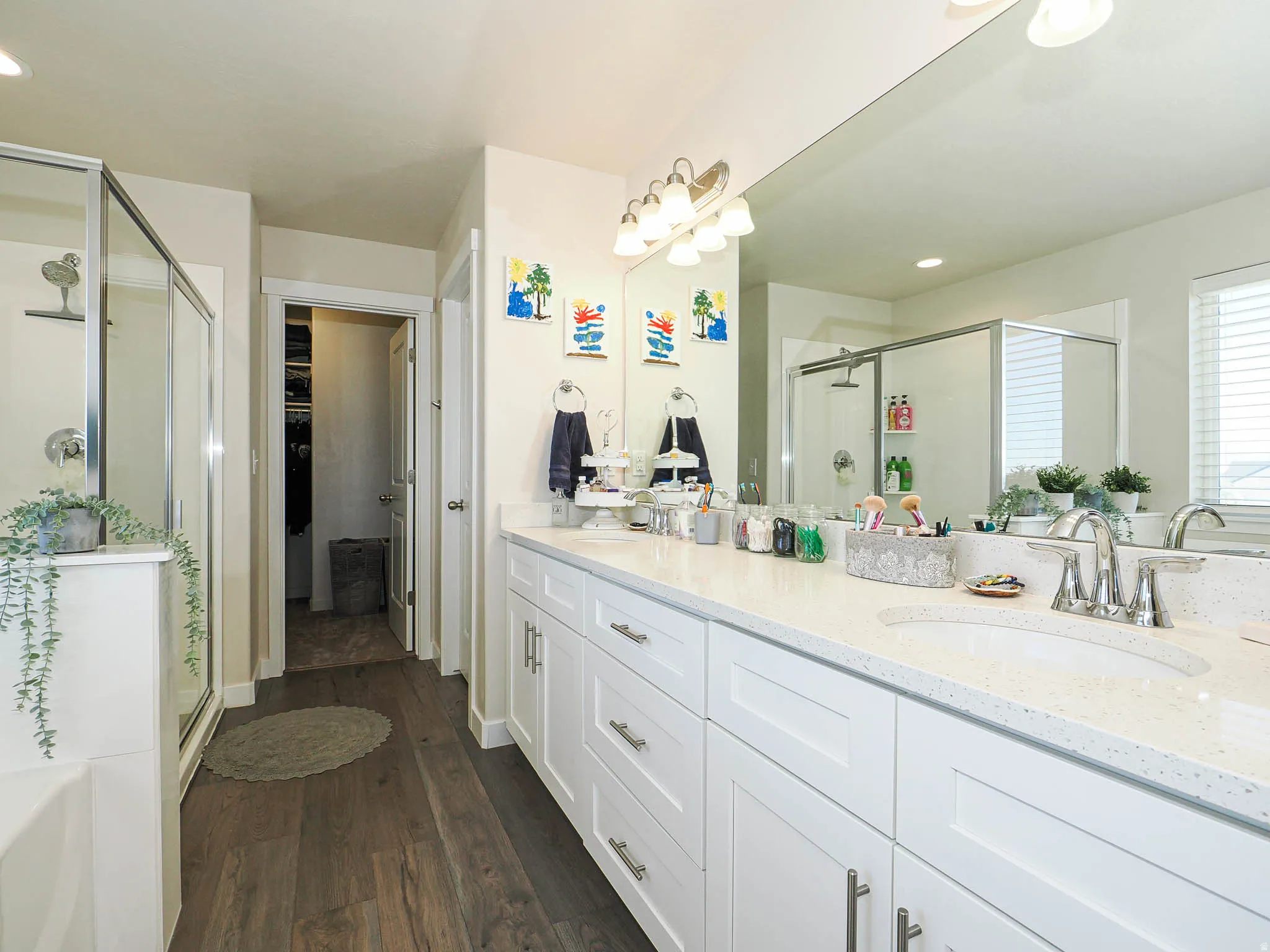 Double vanity with white cabinetry, integrated sinks, and polished chrome fixtures