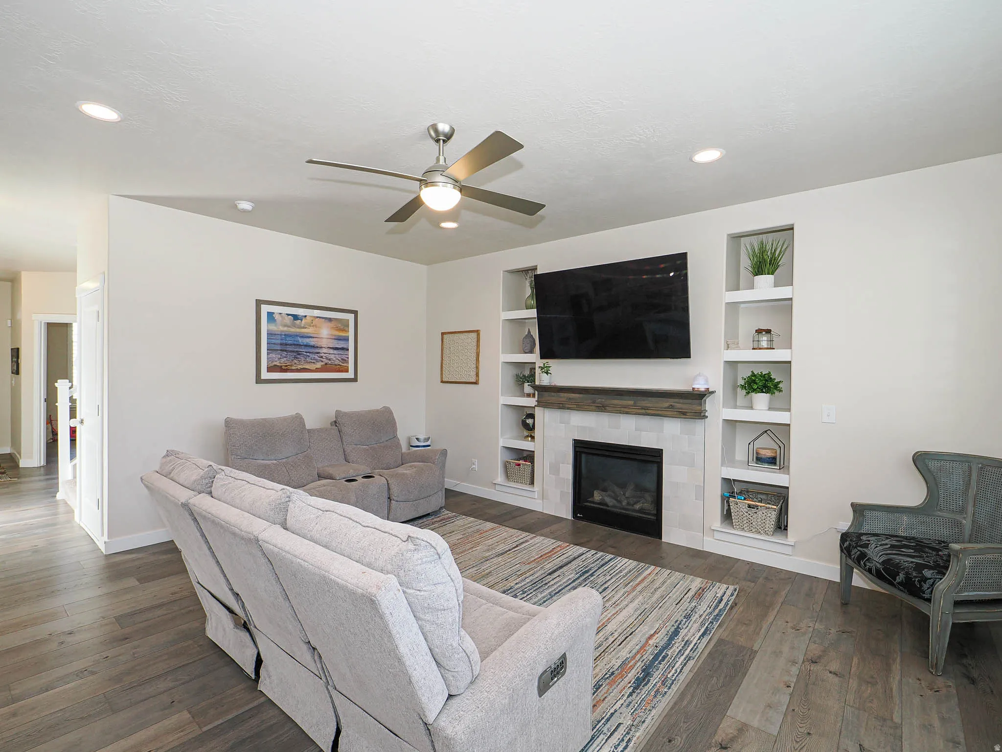 Living area featuring wood-finish flooring, recessed lighting, and a modern ceiling fan