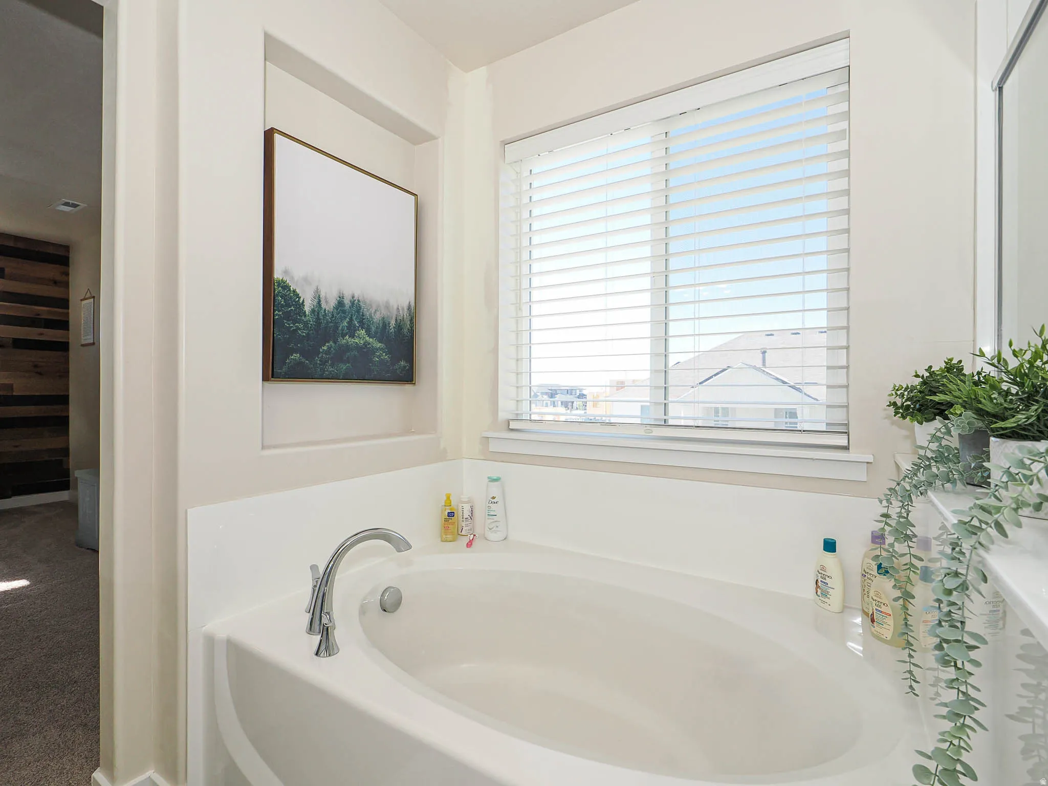 Built-in soaking tub with chrome faucet and white blinds