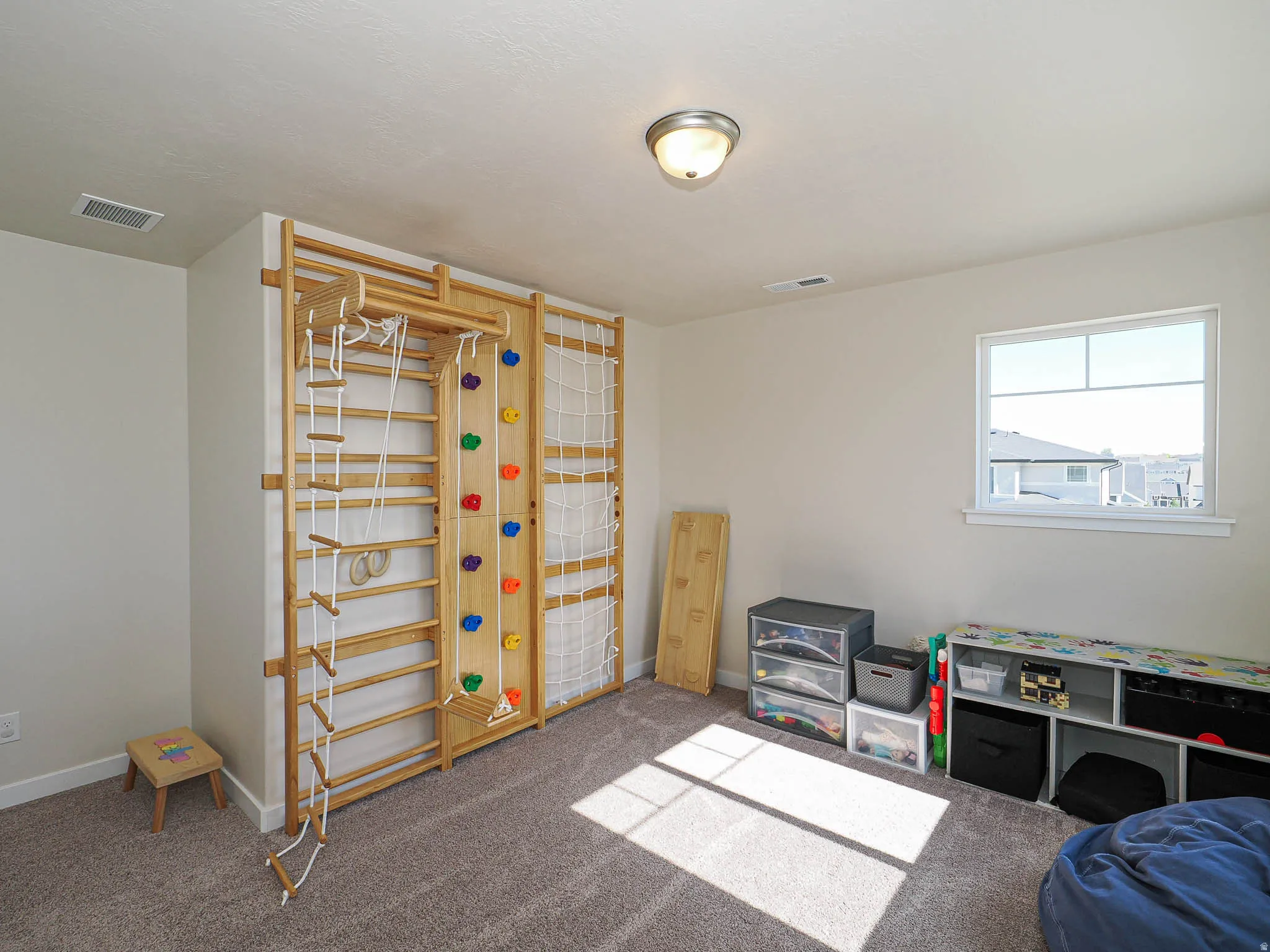 Built-in wooden climbing wall with colorful holds, rope ladder, and net features