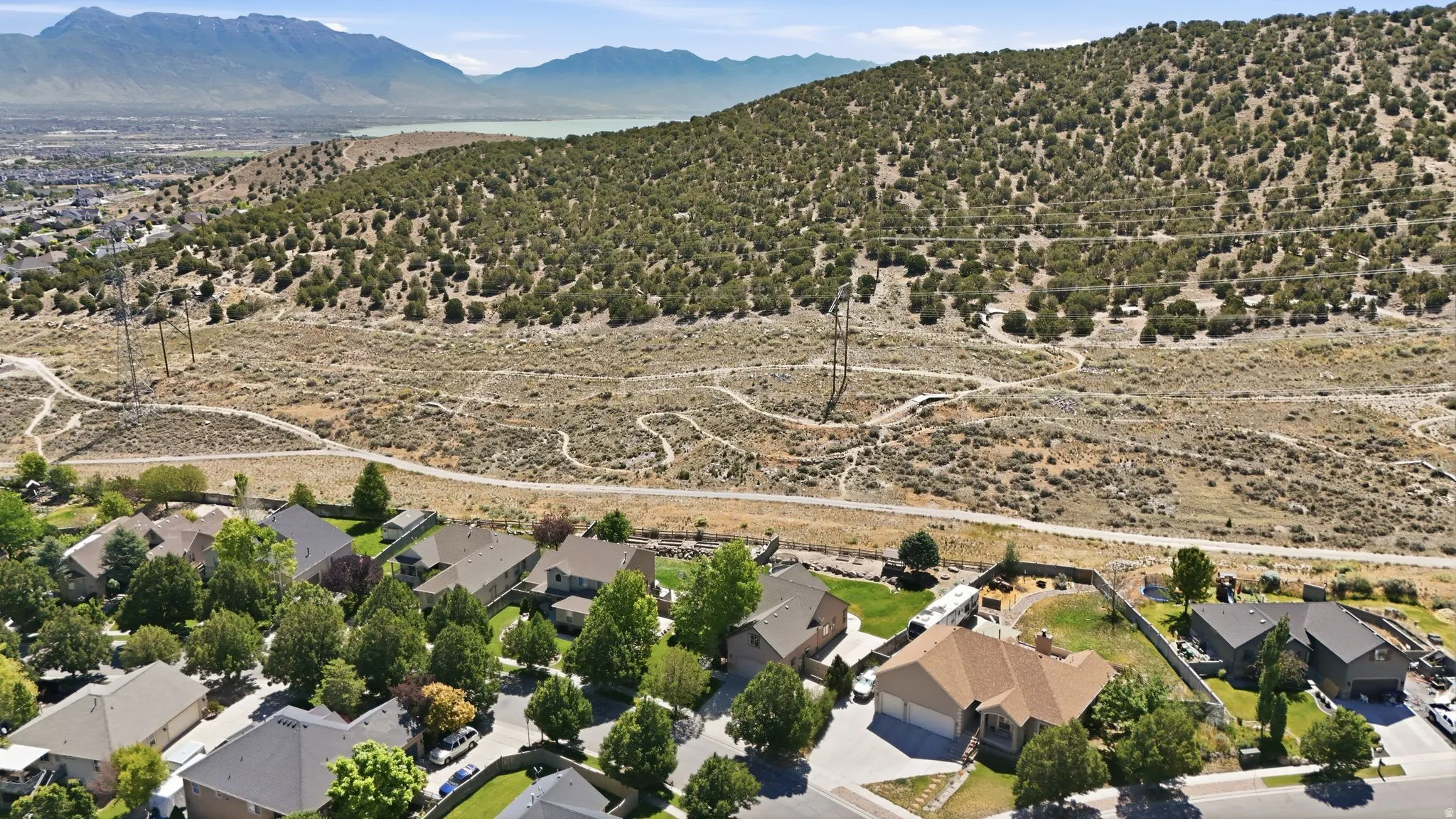 Aerial perspective showcasing residential properties bordering a natural hillside