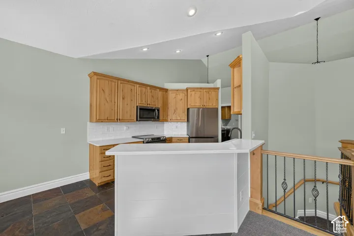 Kitchen area with natural wood cabinetry and white subway tile backsplash