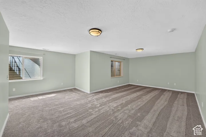 Spacious room featuring new carpeting, two egress windows, and recessed ceiling lighting