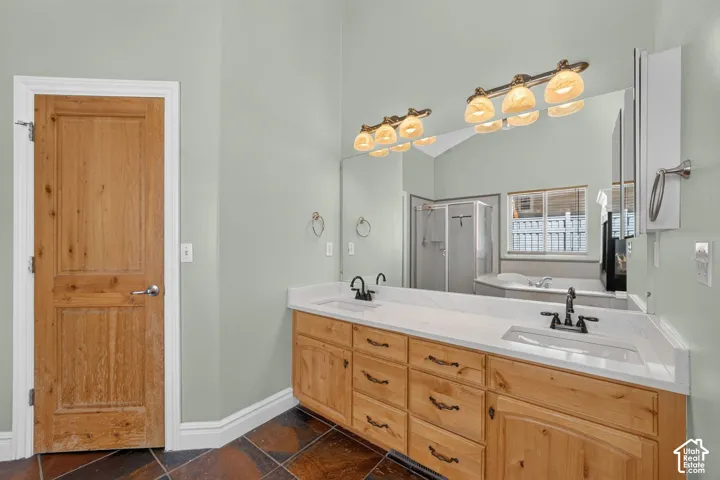 Dual vanity with light wood cabinetry, white countertops, and undermount sinks
