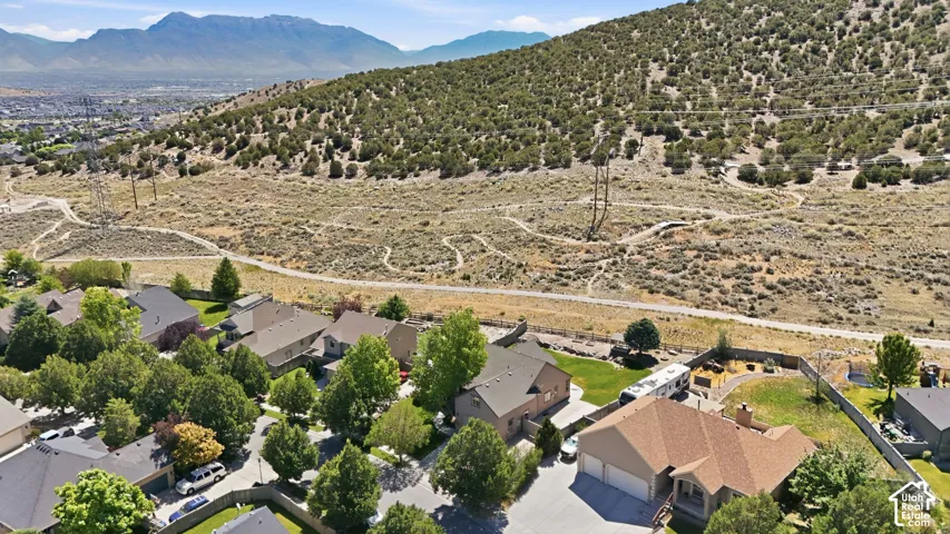Aerial perspective showcasing residential properties bordering an open hillside with established pathways