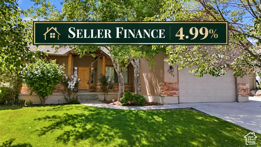Pillared porch entry with wood door, stone facade accents, two-car garage, and established landscaping