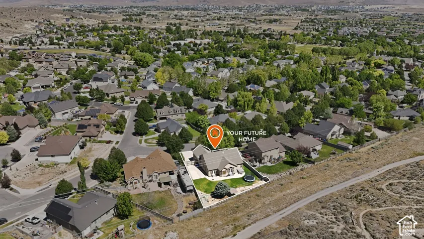 Aerial perspective showcasing a single-family residence within a residential development, surrounded by numerous mature trees