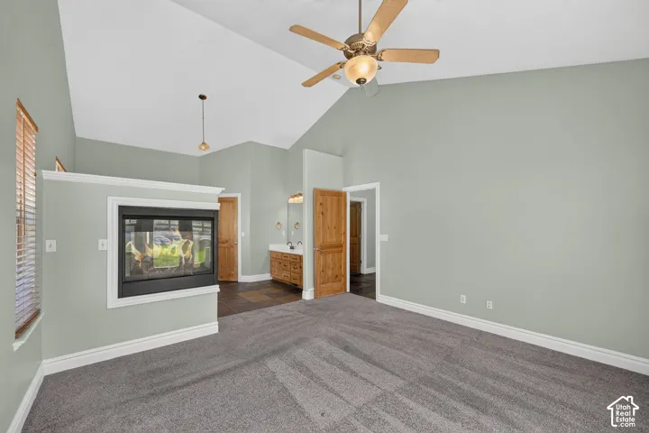 Spacious interior with vaulted ceilings, a built-in fireplace, and a wood-finish ceiling fan