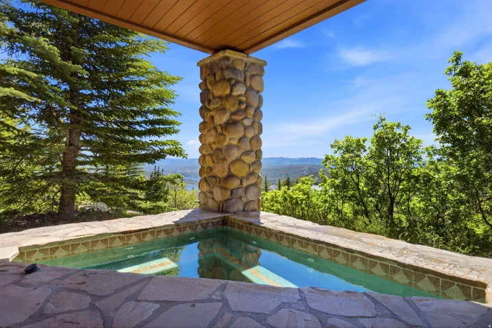 Outdoor spa with flagstone surround and decorative tile inlay