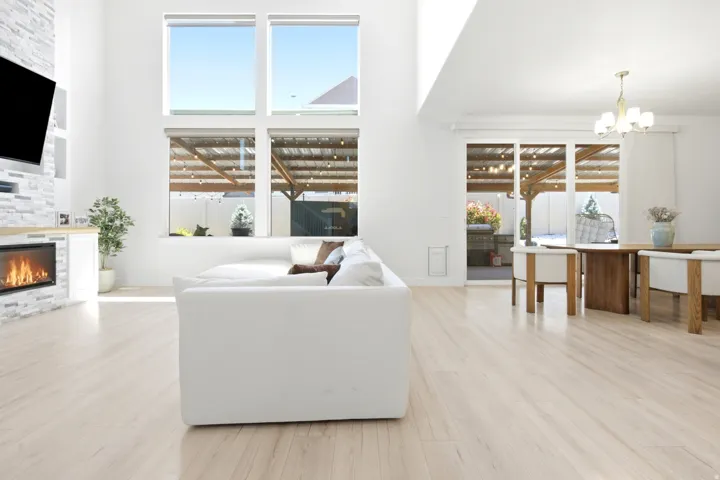 Spacious living area featuring light wood-finish flooring and high ceilings