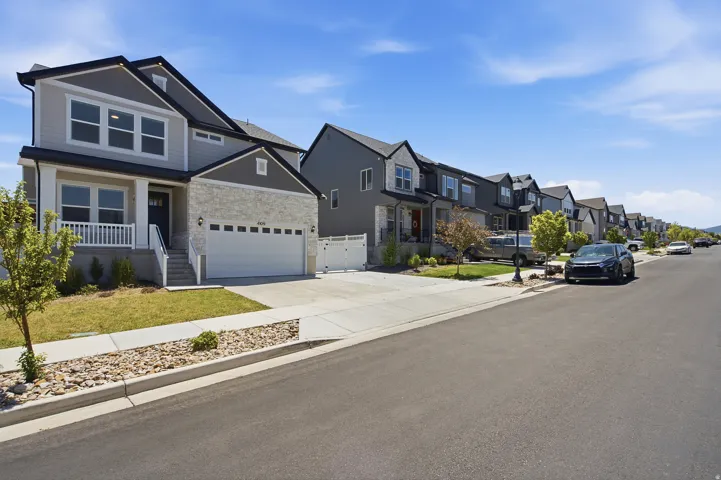 Contemporary two-story residence featuring a light gray and dark gray exterior with stone accents
