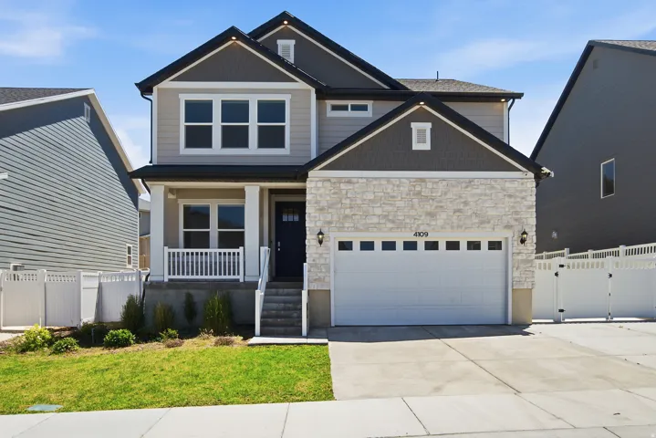 Modern two-story residence featuring light stone veneer and dark gray siding