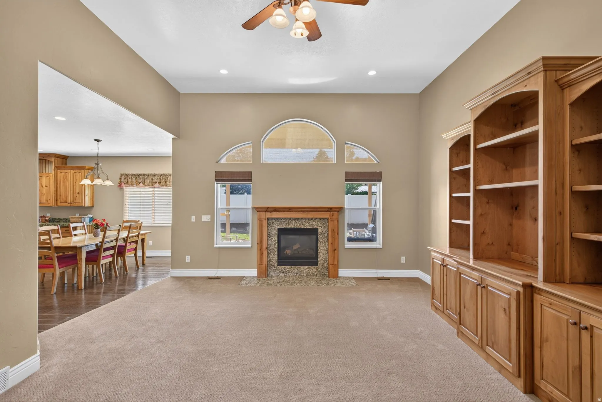 Spacious living room featuring a gas fireplace with a stone surround and wood mantel