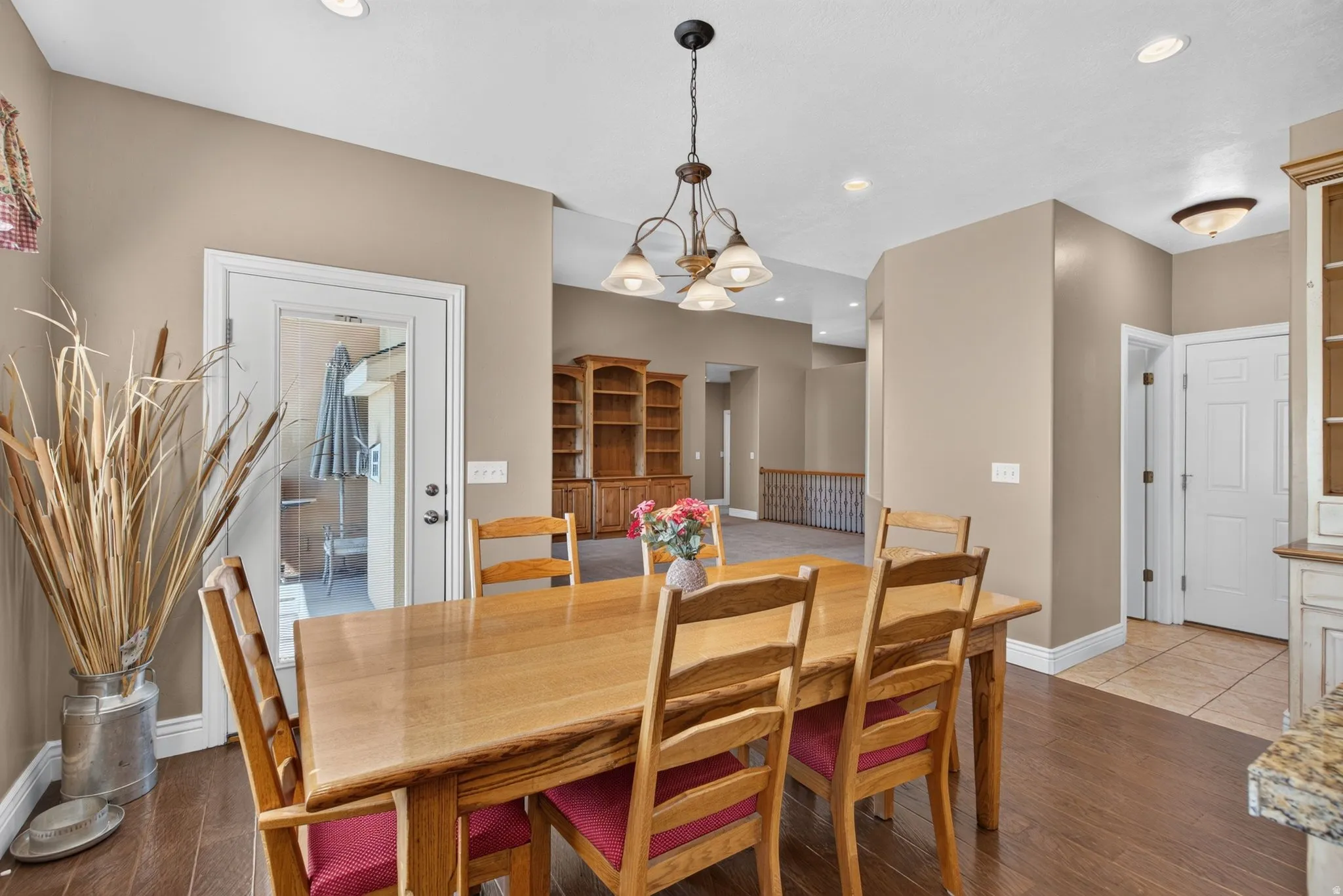 Dining area featuring wood-finish flooring, recessed lighting, and a chandelier