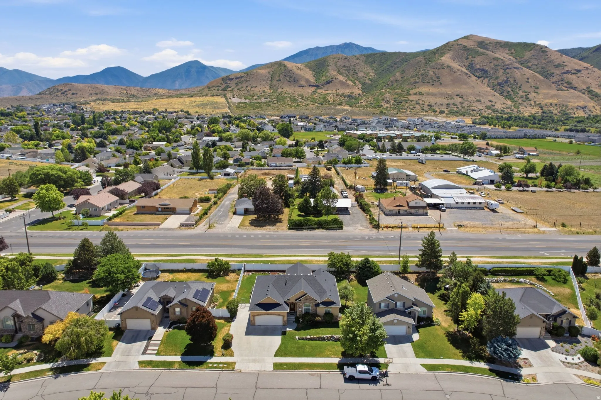 Suburban neighborhood with mature trees and mountain backdrop