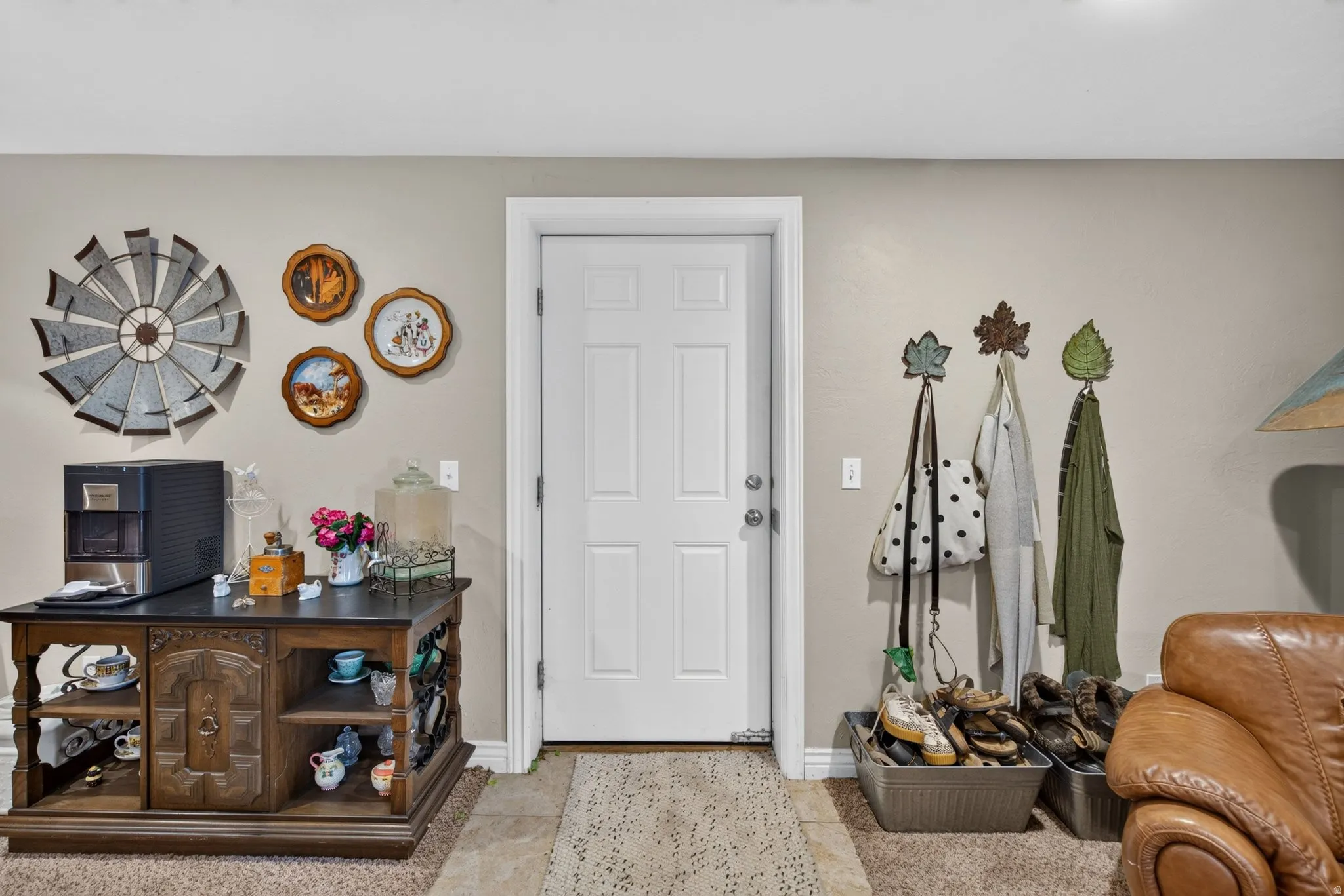 Entryway featuring a six-panel door, neutral wall tones, and varied flooring with carpet and tile