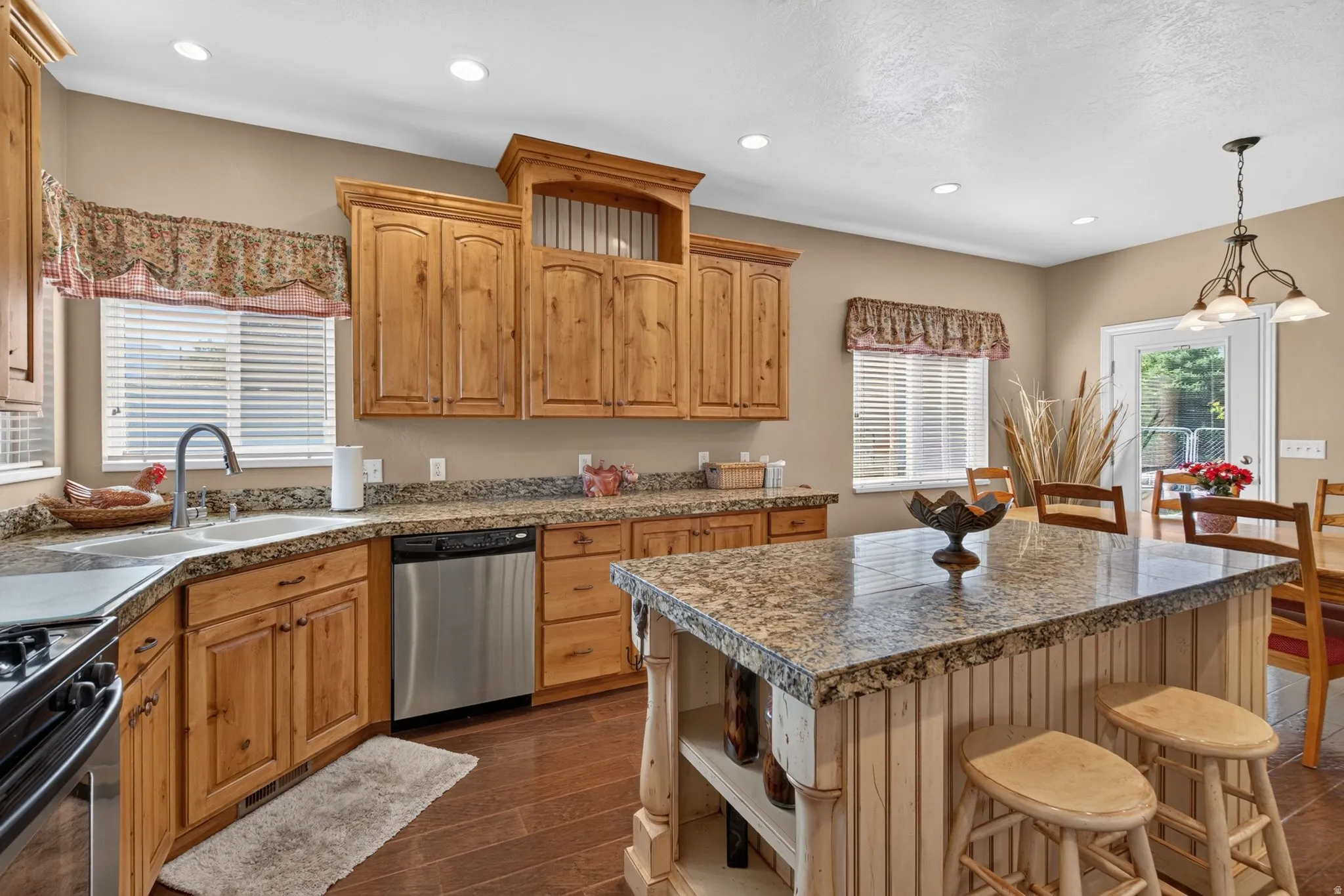 Kitchen featuring wood-finish flooring, recessed lighting, and a kitchen island with a granite-style countertop
