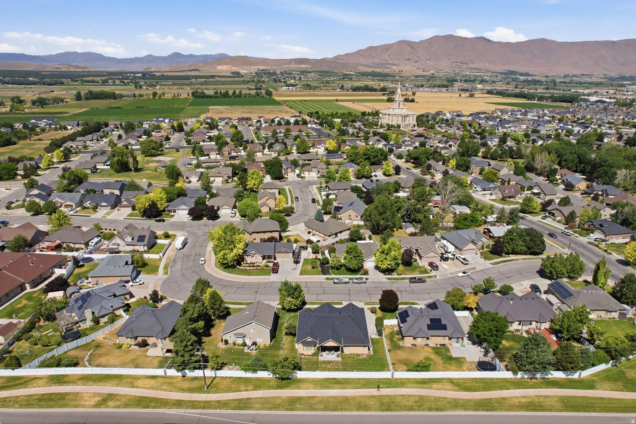 Residential neighborhood featuring single-story homes with dark asphalt shingle roofs and established landscaping