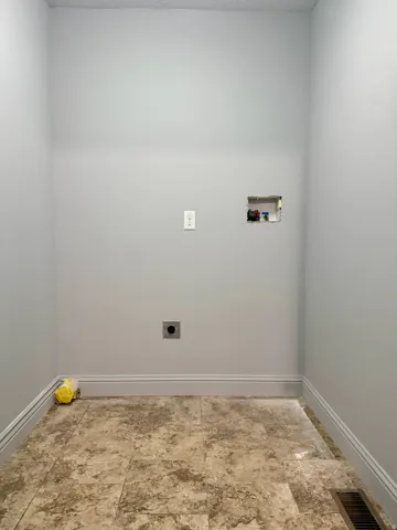 Utility area with stone-look tile flooring and light gray walls