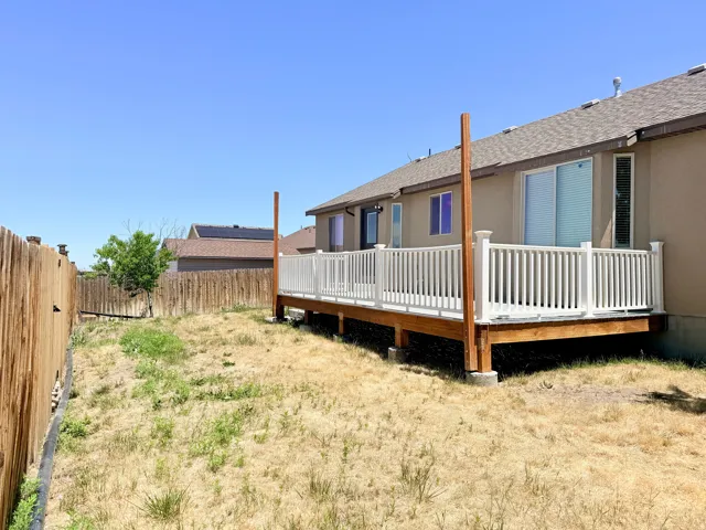 Expansive outdoor deck featuring wood-finish decking and white balustrade railings