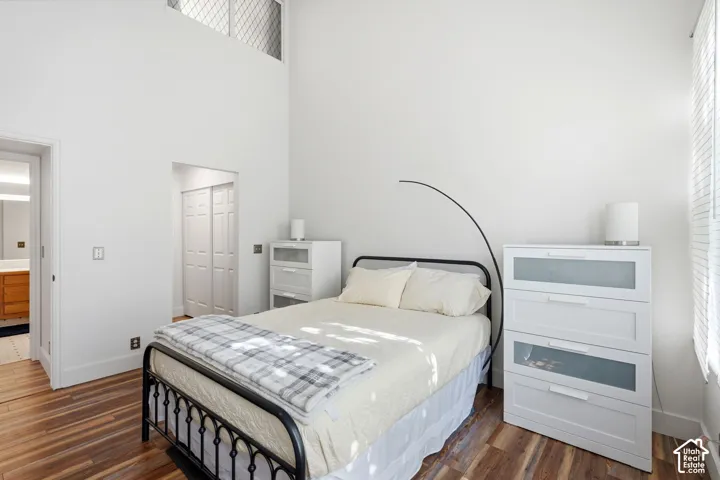 High ceilings with an upper transom window, wood-finish flooring, and white interior walls