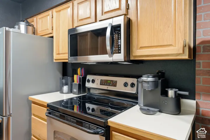 Stainless steel appliance suite featuring a refrigerator, range, and over-the-range microwave