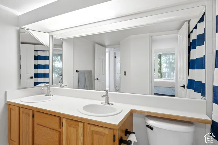 Double vanity with integrated sinks, brushed nickel faucets, and wood-finish cabinetry
