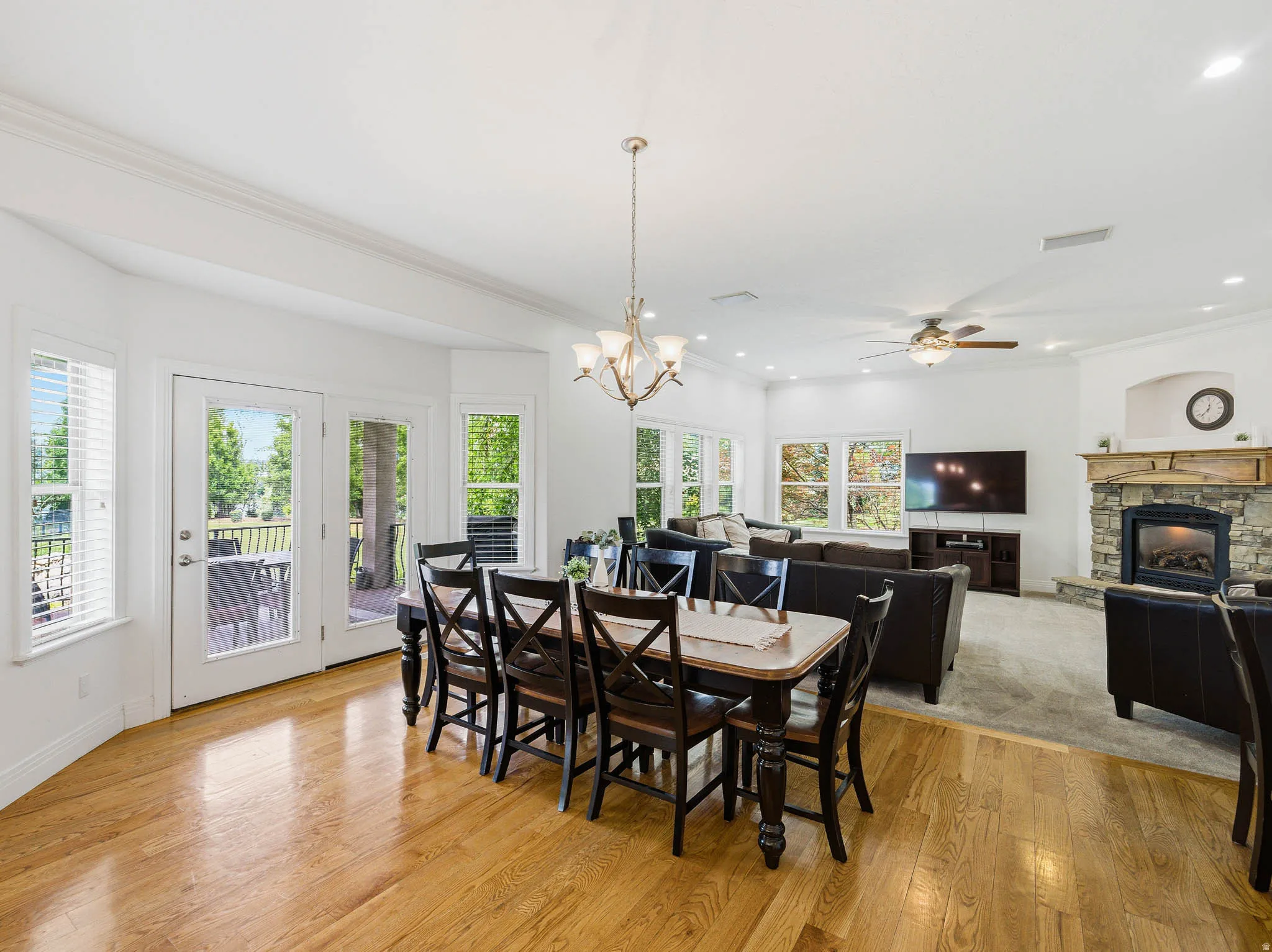 Spacious dining area featuring wood-finish flooring, a contemporary chandelier, and French doors leading to an exterior deck