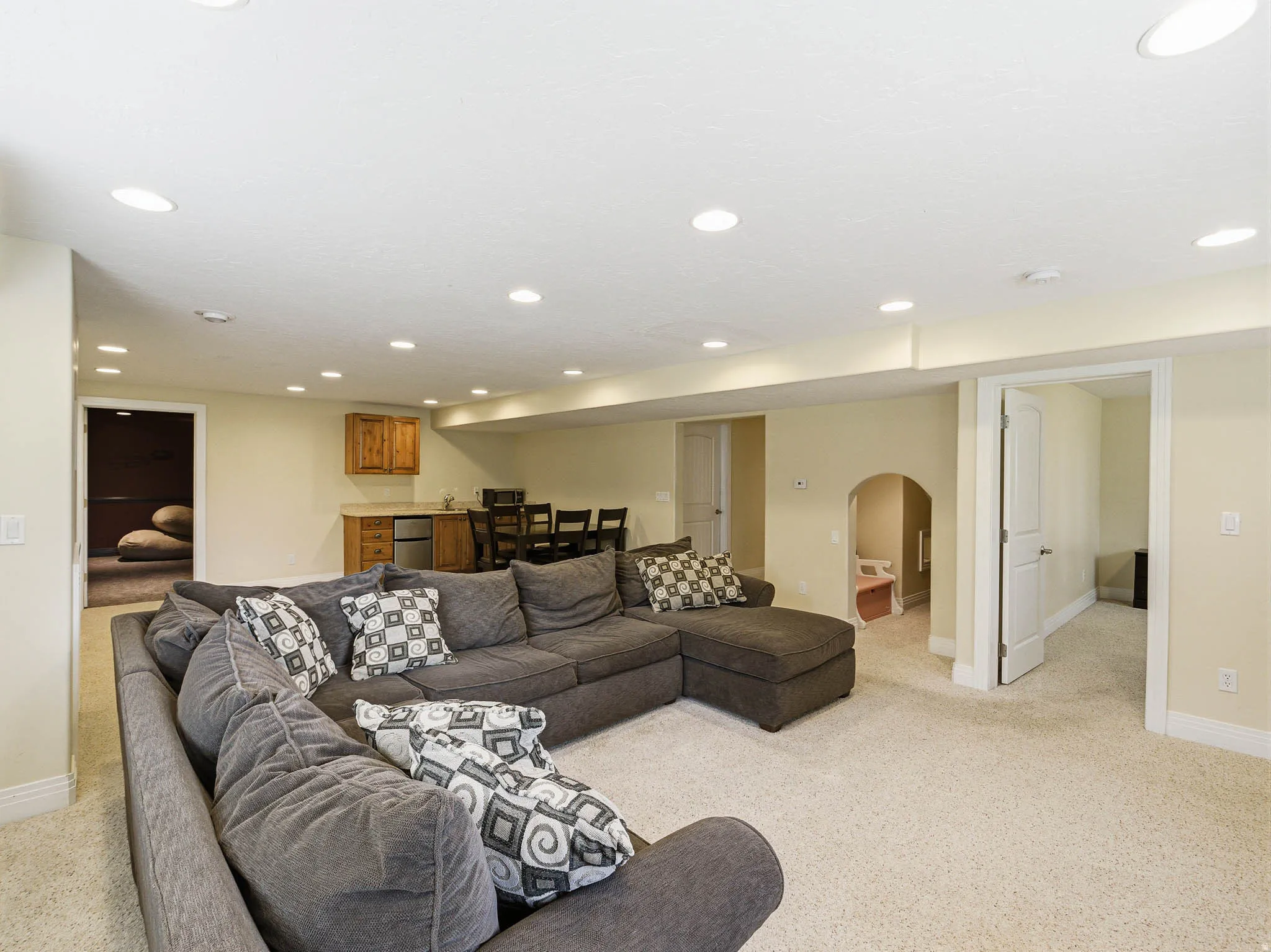 Expansive carpeted recreation room with recessed lighting