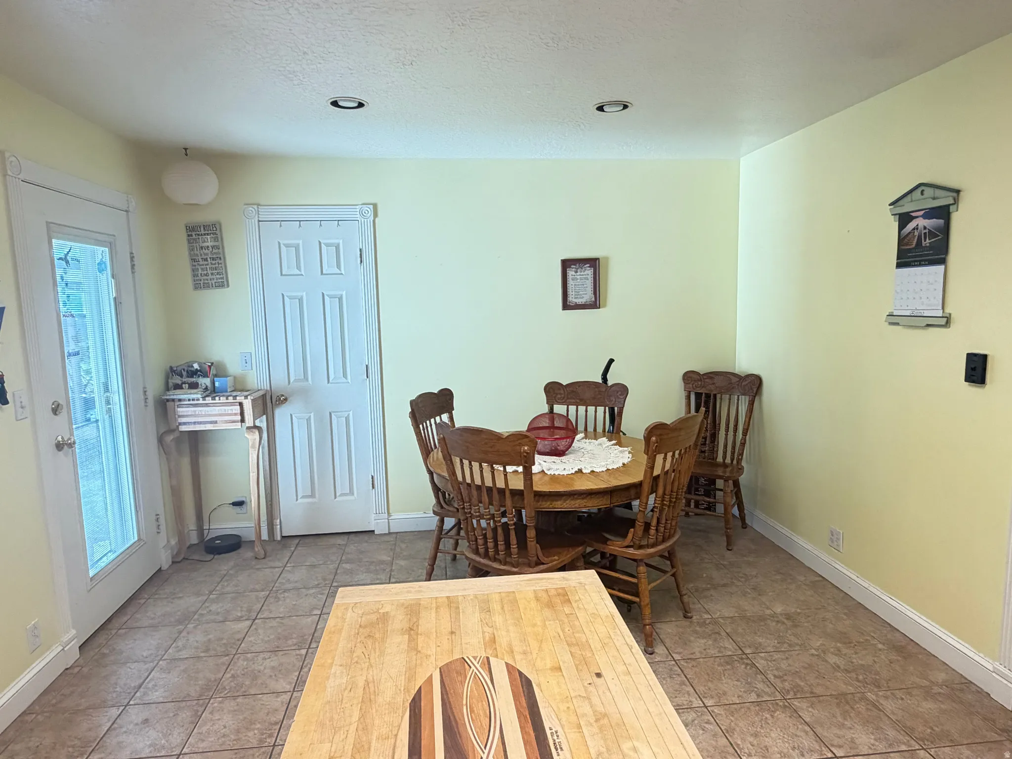 Kitchen area featuring tile flooring, recessed lighting, and a white paneled door