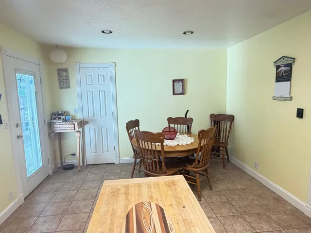 Kitchen area featuring tile flooring, recessed lighting, and a white paneled door