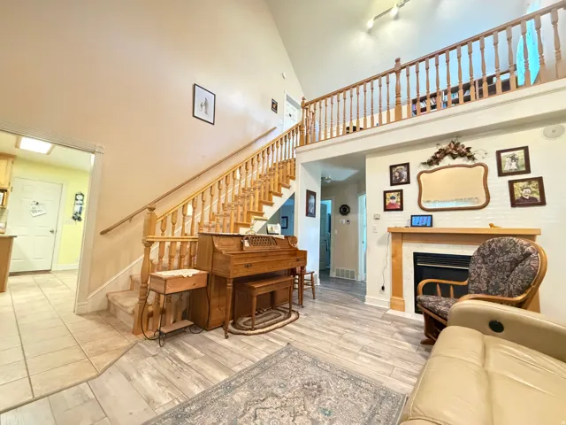 Vaulted living space featuring a wood-finish staircase and an open upper-level railing