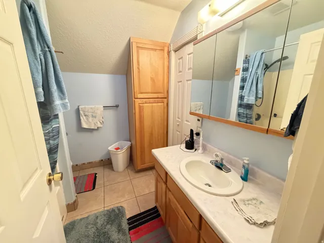 Bathroom vanity with an integrated sink, laminate countertop, and wood-finish cabinetry