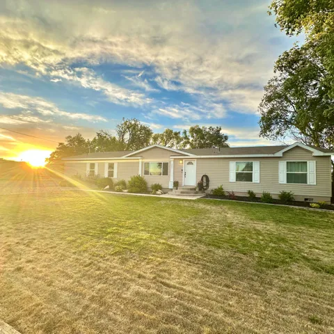 Ranch-style residence featuring light-toned siding, white trim, and a white front door
