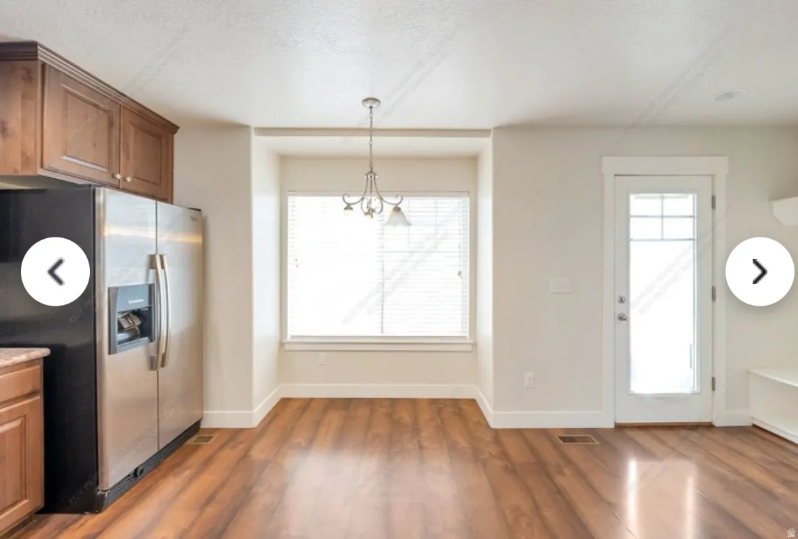 Spacious interior featuring wood-finish flooring, a built-in window seat, and a glass-paneled exterior door