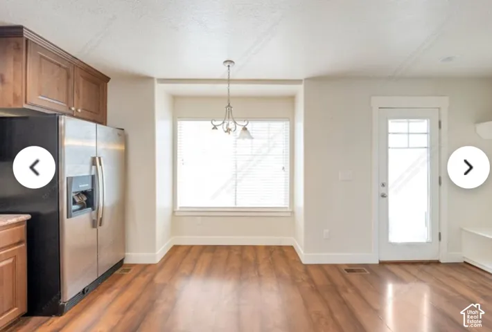 Spacious interior featuring wood-finish flooring, a built-in window seat, and a glass-paneled exterior door
