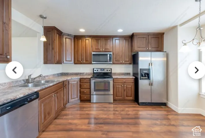 Kitchen featuring wood-finish flooring, dark wood cabinetry, and stainless steel appliances
