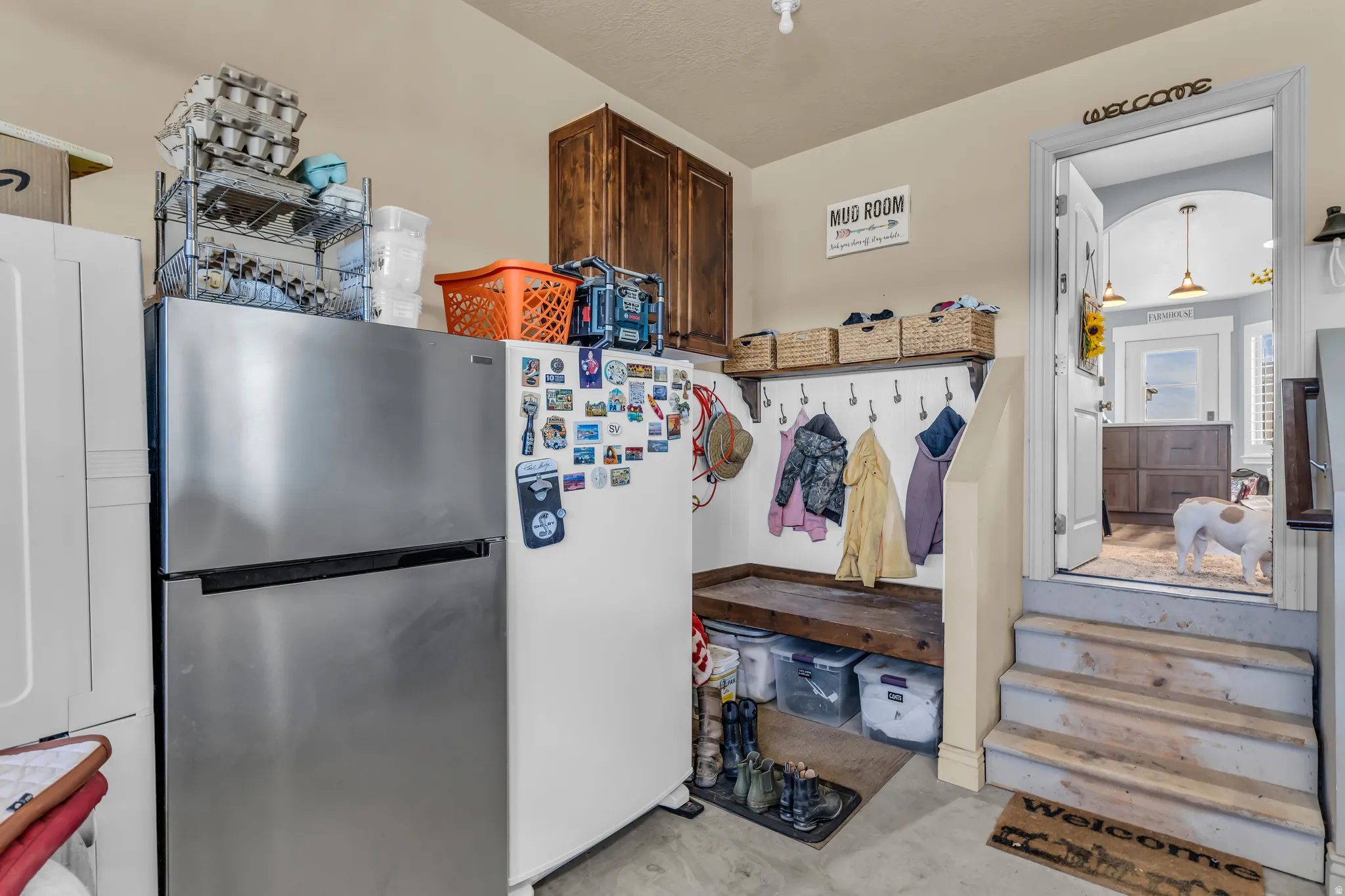 Functional mudroom area featuring a built-in bench with storage, multiple coat hooks, and overhead shelving